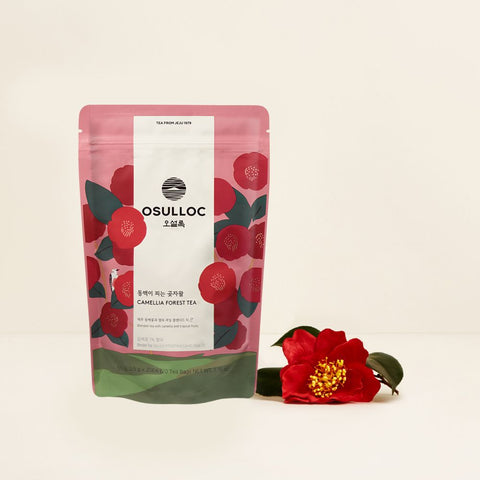 OSULLOC Camellia Forest Tea — Floral pink pouch beside a red camellia flower.