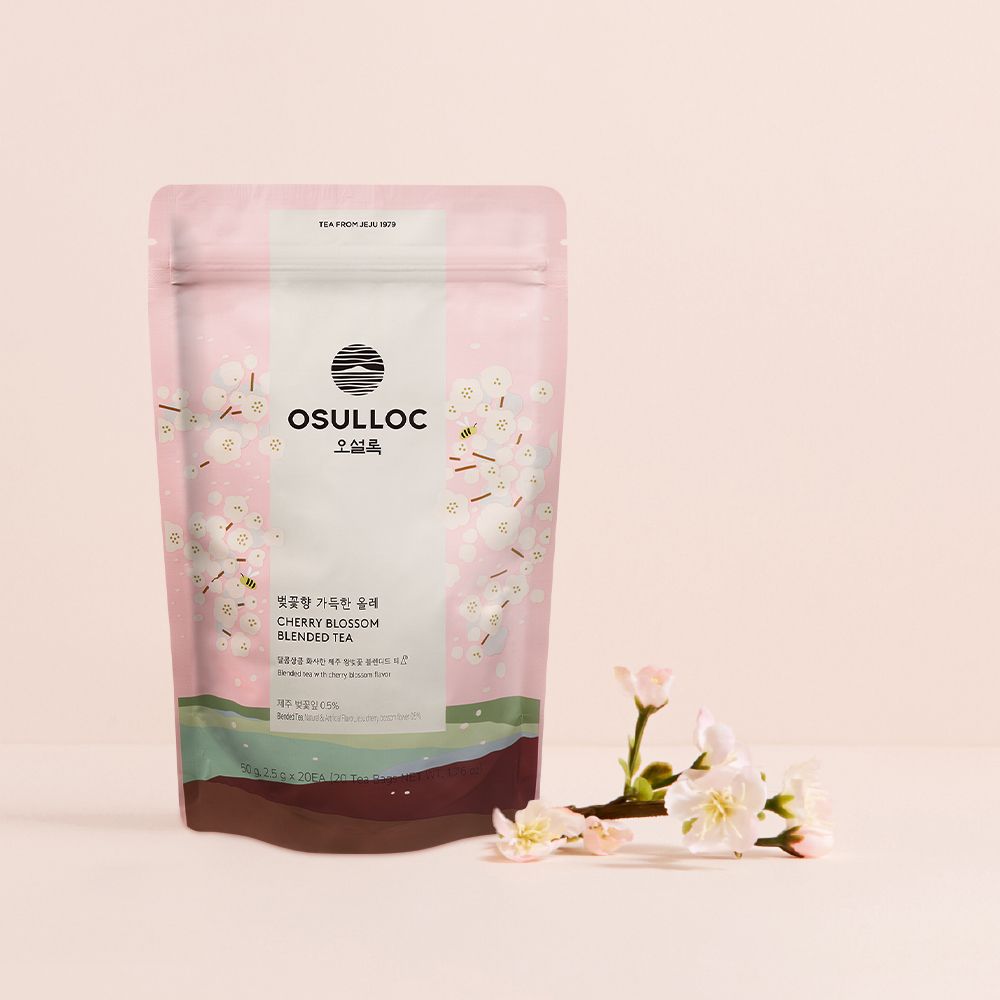 OSULLOC Cherry Blossom Tea — Pale pink floral pouch beside a flowering branch.