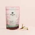 OSULLOC Cherry Blossom Tea — Pale pink floral pouch beside a flowering branch.