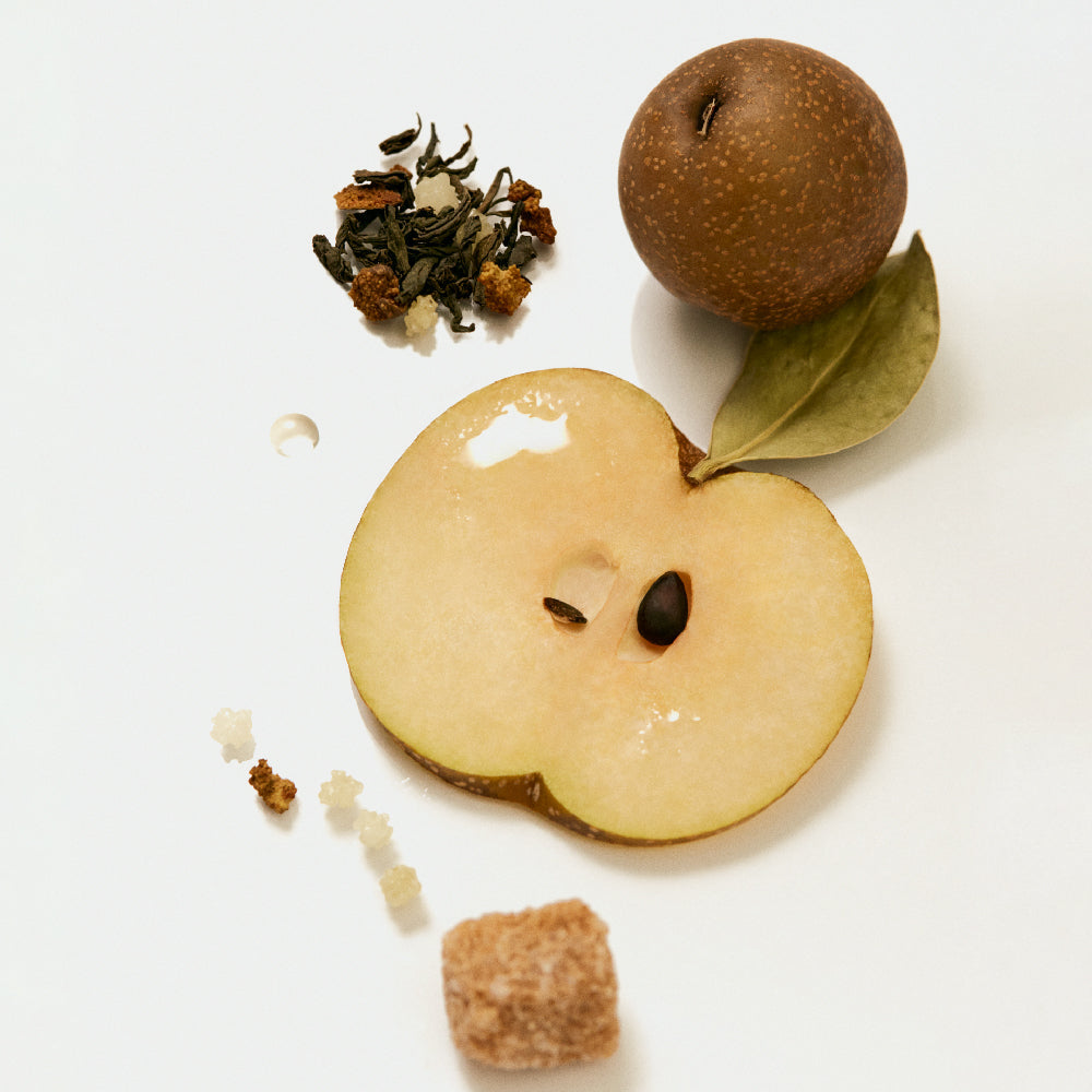 OSULLOC Moon Walk Tea — Whole and sliced pear beside loose tea, small white granules and a brown cube.