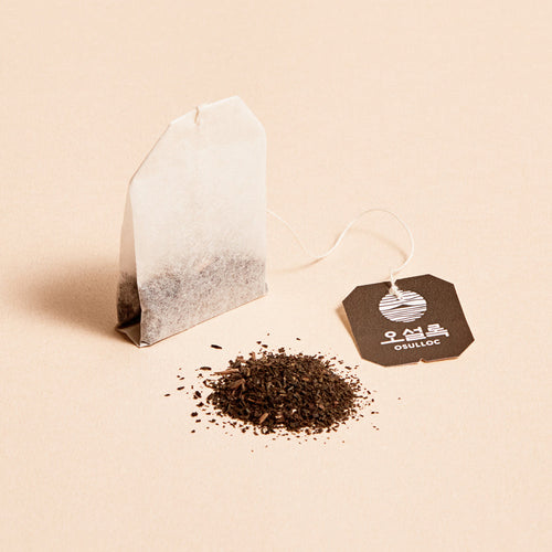 OSULLOC Jeju Volcanic Oolong Tea — Paper tea bag beside loose dark tea and an OSULLOC tag.