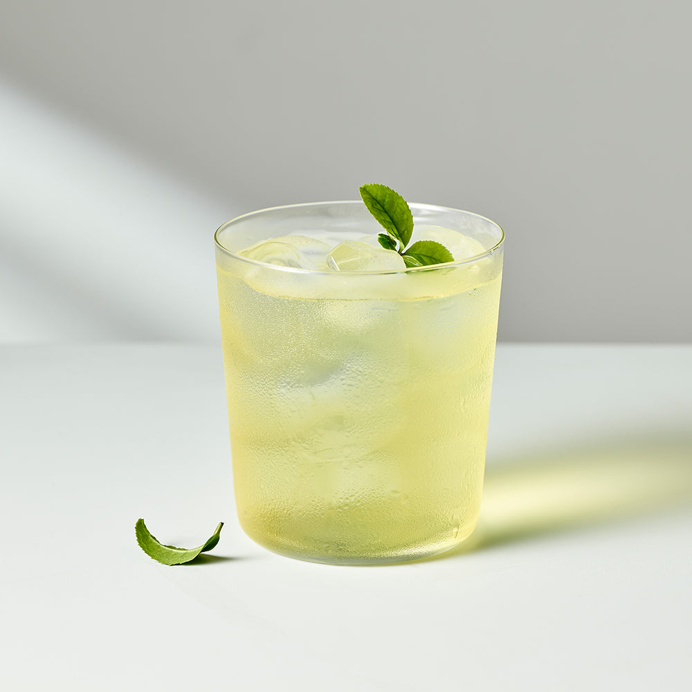 OSULLOC Pure Green Tea — Pale green iced tea with fresh leaves in a clear glass.