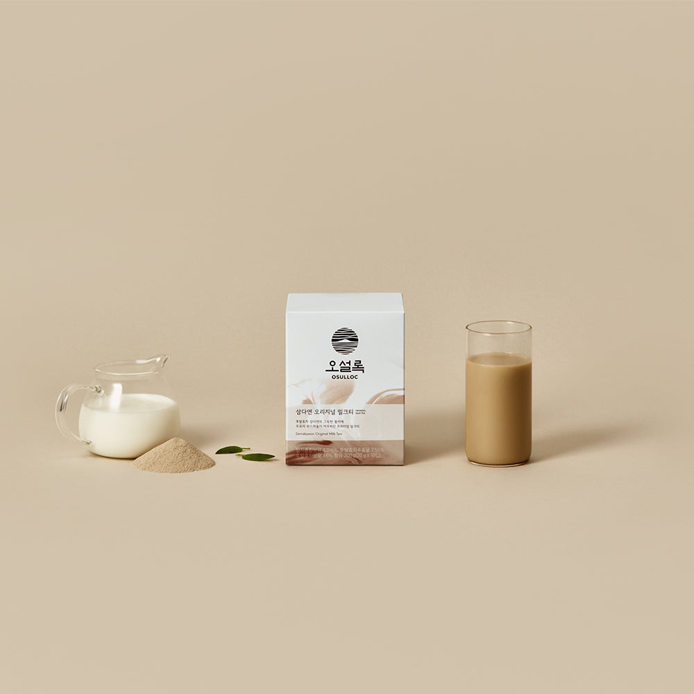 OSULLOC Original Milk Tea — Milk tea box and glass beside a small jug of white liquid, powder and two leaves.