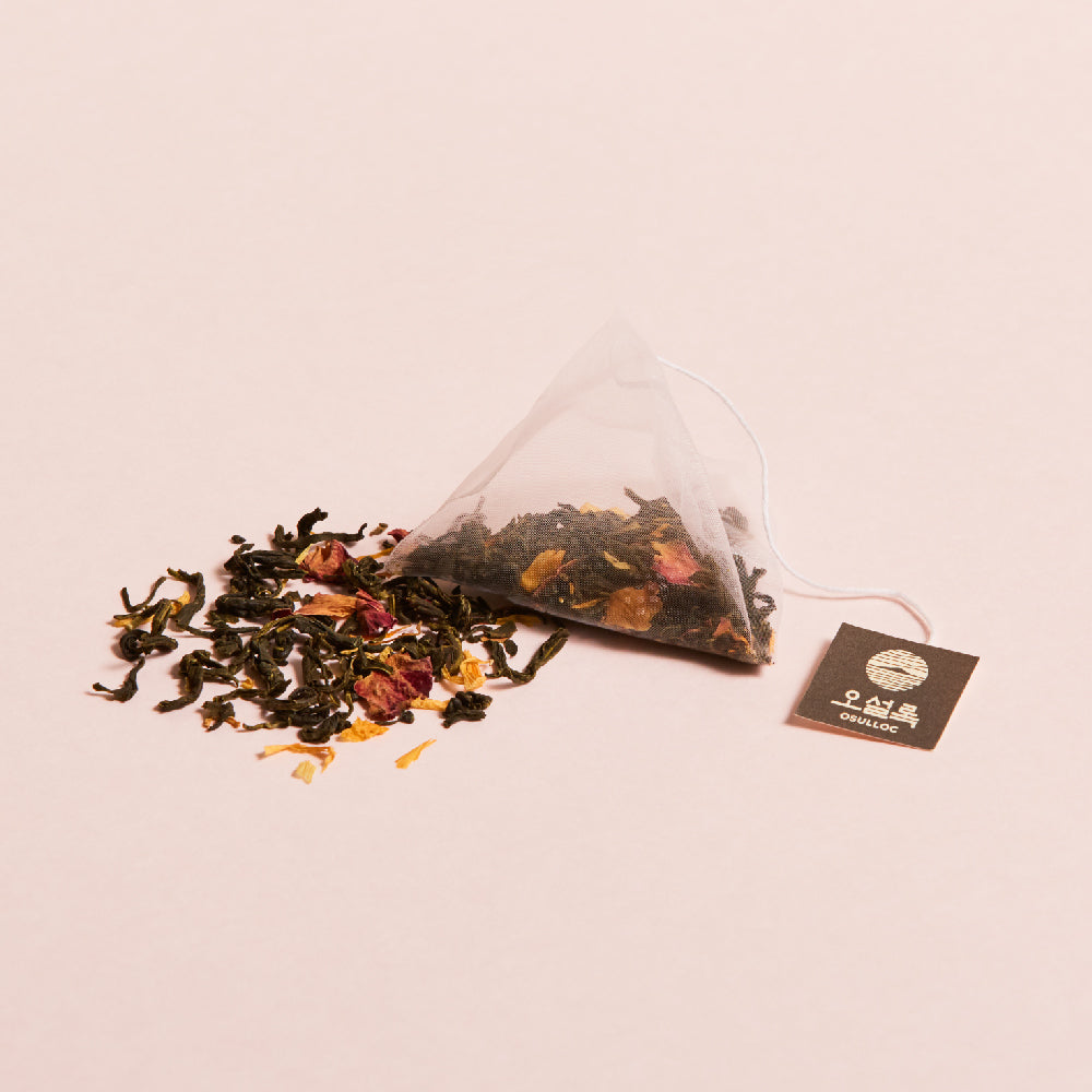 OSULLOC Wedding Green Tea — Pyramid tea bag beside a loose tea blend with flower petals.