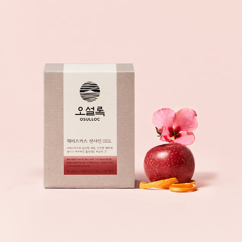 OSULLOC Hibiscus Sunshine — Grey-and-white box beside a red apple, flower and citrus peel.