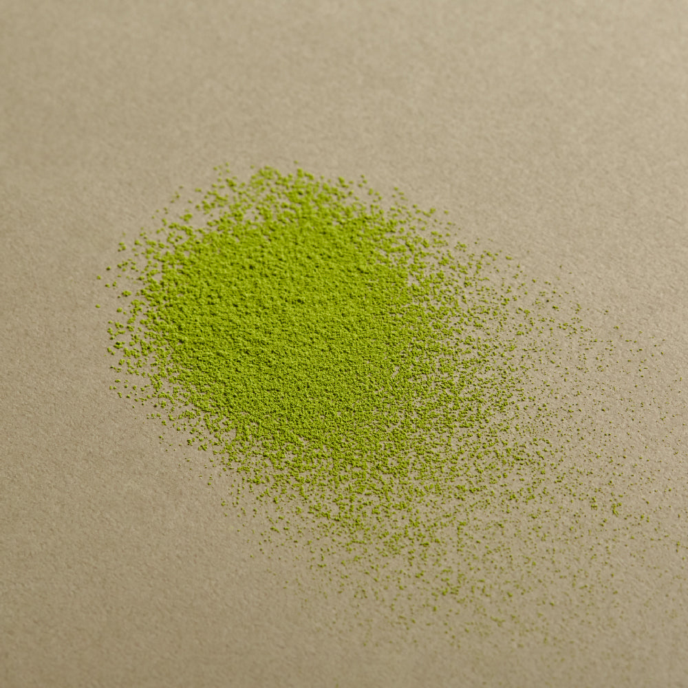 OSULLOC Premium Jeju Matcha Powder 40 g — Fine green matcha powder scattered on an olive surface.
