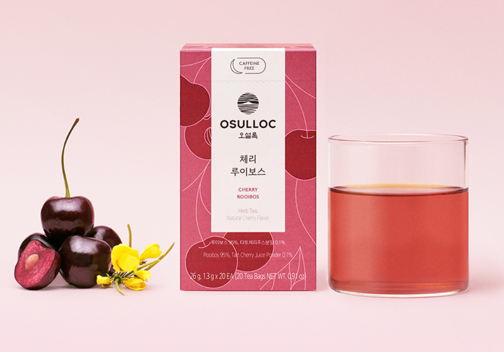 OSULLOC Herbal Tea Life Set — Red rooibos box beside cherries, yellow flowers and a glass of red infusion.