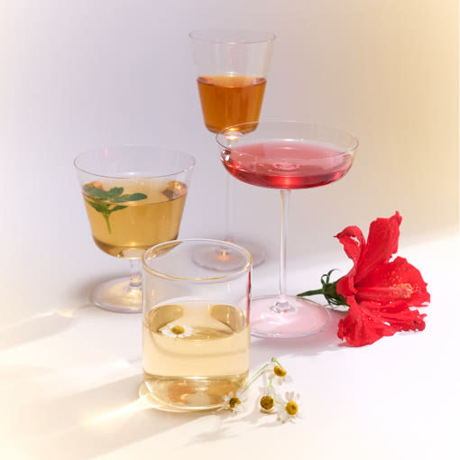 OSULLOC Tea Edition Herb Gift Box — Four glasses of colourful infusions beside red and white flowers.