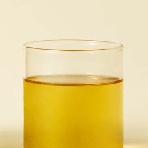OSULLOC Tangerine Blossom Oolong Tea — Té dorado en un vaso transparente.