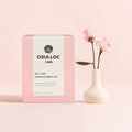 OSULLOC Wedding Green Tea — Caja rosa junto a un pequeño jarrón blanco con flores rosas.