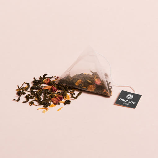 OSULLOC Wedding Green Tea — Bolsita piramidal y mezcla suelta con pétalos de colores sobre rosa.
