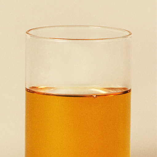 OSULLOC Tangerine Blossom Oolong Tea — Amber tea in a clear glass.