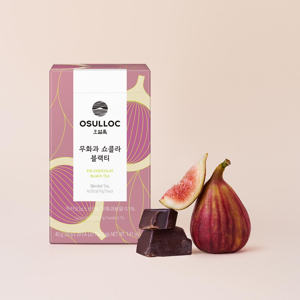 OSULLOC Fig Chocolat Black Tea — Caja rosa y crema junto a higos y trozos de chocolate negro.