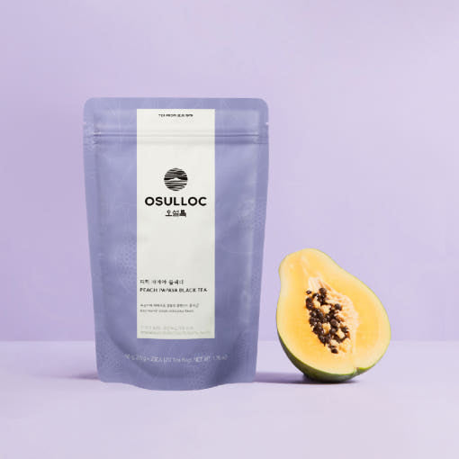OSULLOC Peach Papaya Black Tea — Purple Peach Papaya pouch beside half a papaya.