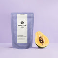 OSULLOC Peach Papaya Black Tea — Purple Peach Papaya pouch beside half a papaya.