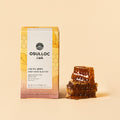 OSULLOC Sweet Honey Black Tea — Caja amarilla junto a panales de miel apilados.