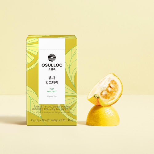 OSULLOC Yuja Earl Grey — Yellow-and-green Yuja Earl Grey box beside cut yellow citrus.